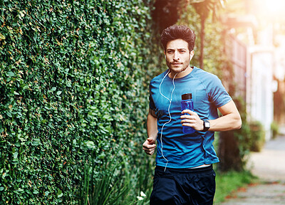 Buy stock photo Street, man and earphones with running for fitness or workout and exercise with music in London. Runner, speed and dedication with routine for wellbeing or wellness and training with water bottle