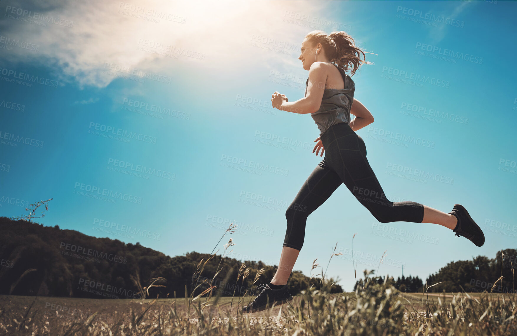 Buy stock photo Music, exercise and woman running at park for healthy body, wellness or fitness workout. Earphones, cardio and trail runner training in nature for race, marathon and low angle outdoor with athlete