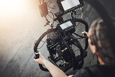 Buy stock photo Videographer, camera and man filming in studio for photography, production and media. Behind the scenes, backstage and person with stabilizing equipment on set shooting videos, documentary or film