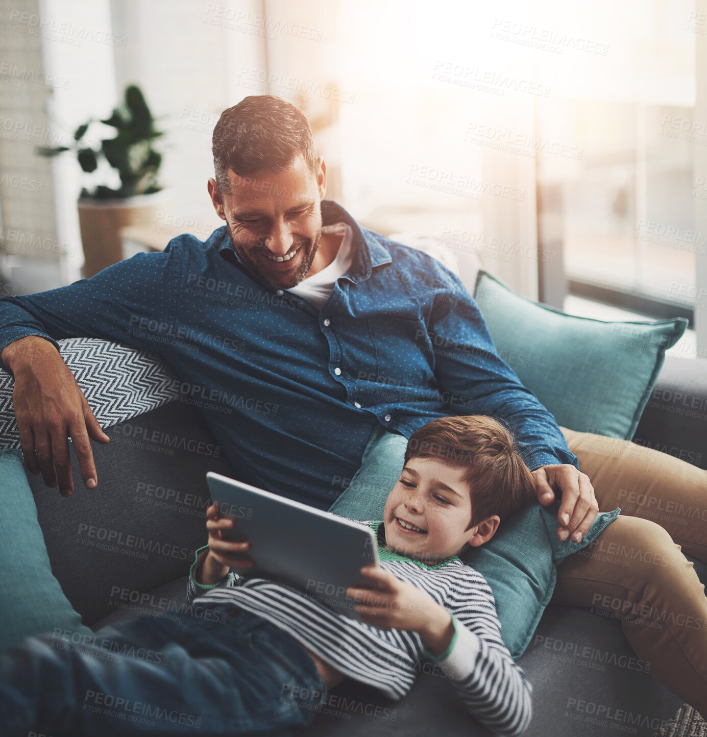Buy stock photo Happy, man and kid with tablet on sofa for online gaming, entertainment and bonding together. Family, home and son with tech by father for network, connection and download of app in living room