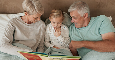 Buy stock photo Grandparents, girl and reading book in bed for storytelling, literature and bonding at sleepover. Home, grandchild and people learning together for love, language and grandma or grandpa for fairytale