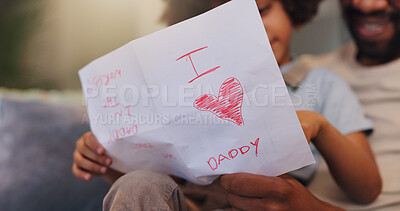 Buy stock photo Dad, letter and relax with son for love, heart or present on sofa for fathers day surprise at home. Papa, child or little boy reading note of appreciation, gratitude and care to parent for childhood