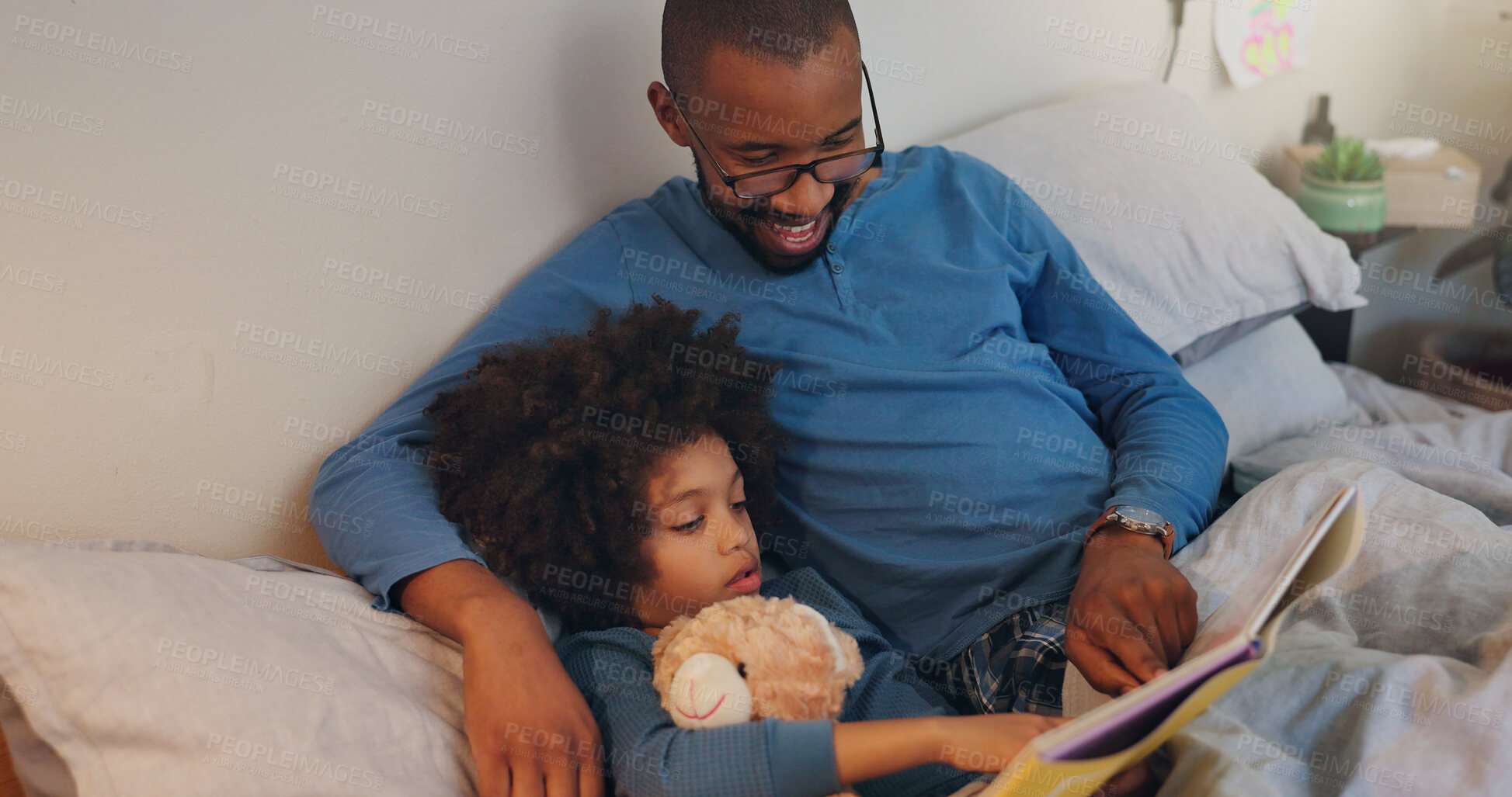 Buy stock photo Relax, child and dad reading book in bed for education, learning or language development in bedroom. Night, African man and young boy with teddy bear for literacy, storytelling or knowledge in home