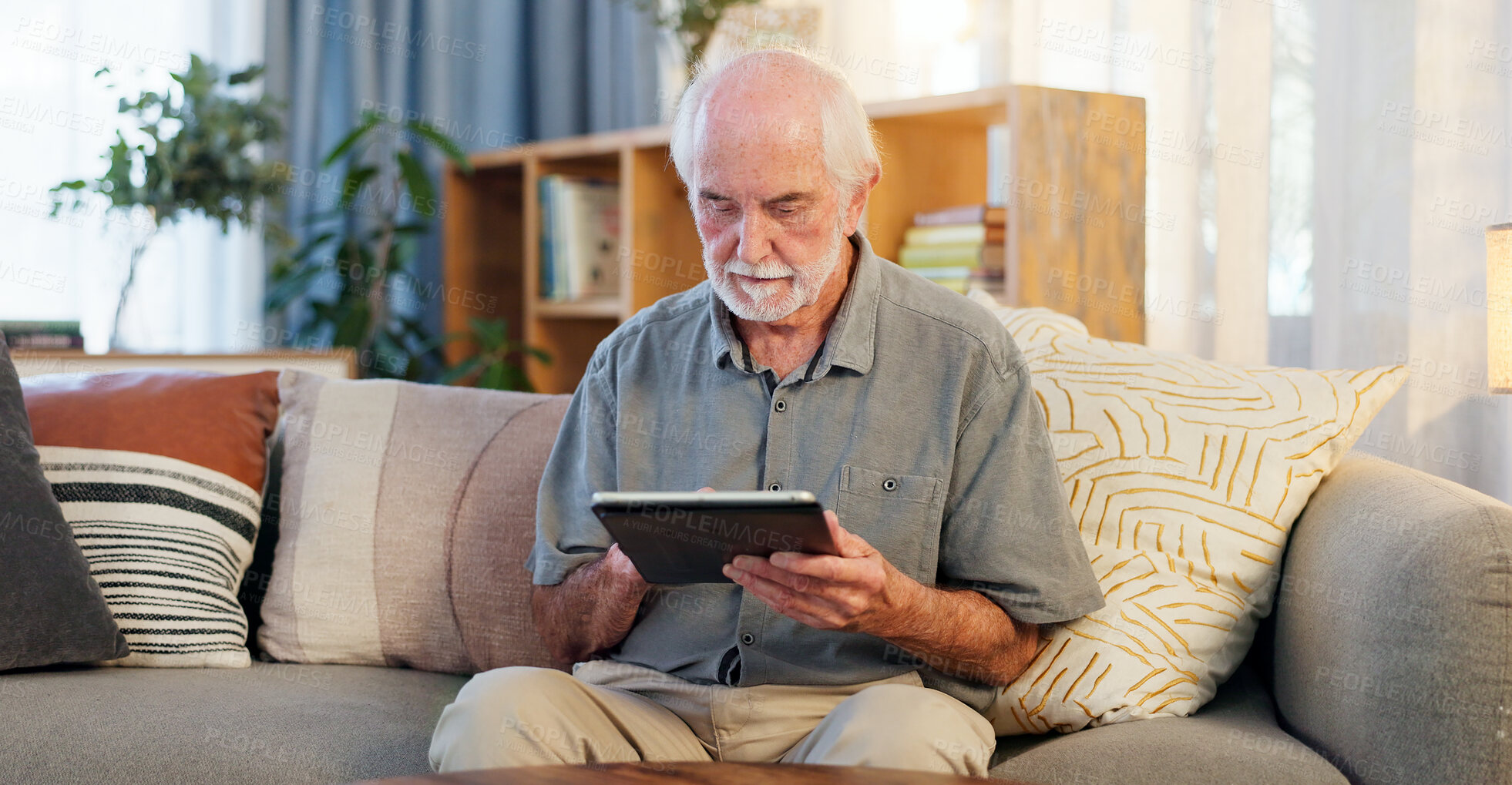 Buy stock photo Senior man, tablet and typing on sofa for web surfing with retirement, memory game or connection in home. Elderly person, tech and relax with reading ebook, online puzzle or internet scroll in lounge