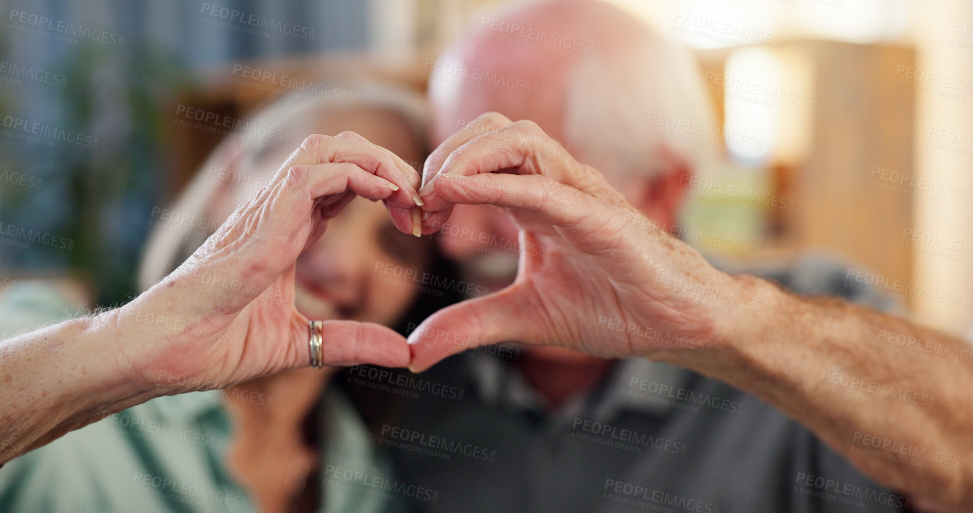 Buy stock photo Senior couple, hands and heart symbol in retirement home with smile for care, love and support. People, relationship and happy as pensioner for marriage, trust and commitment or romance as soulmates