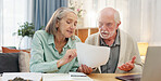 Home, laptop and elderly couple with documents in discussion for financial bills, insurance and plan. Tech, retirement and senior people with paper by table for healthcare debt, invoice and budgeting