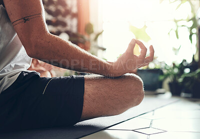 Buy stock photo Shot of an unrecognisable man meditating in the lotus position at home