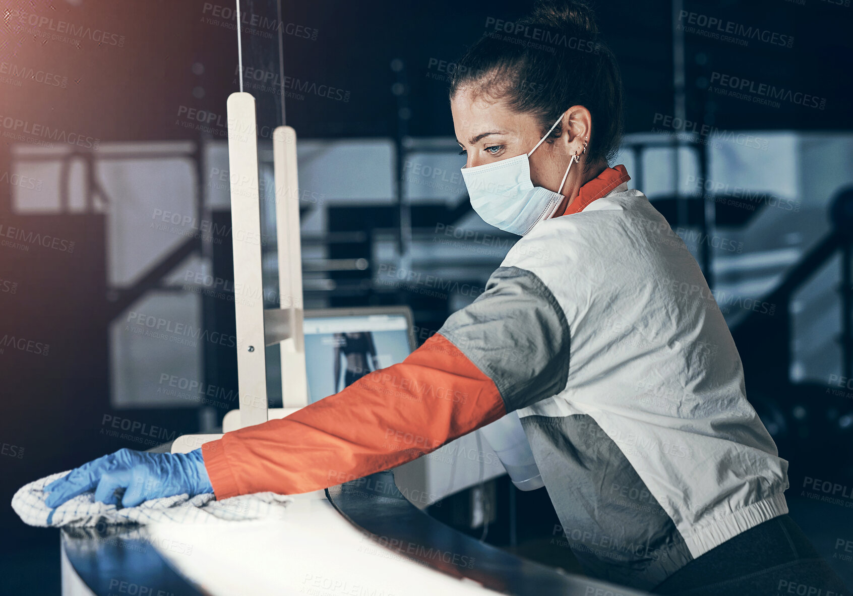 Buy stock photo Shot of a young woman cleaning the reception desk in a gym