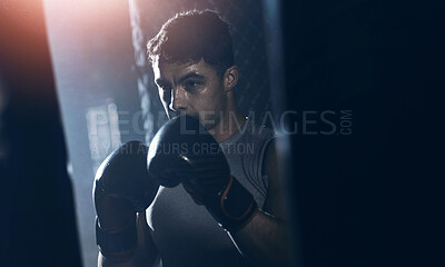 Buy stock photo Shot of a young man practicing his boxing routine at a gym