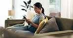 Girl, phone and typing in house on sofa for communication, relax and mobile app with social media scroll. Woman, smartphone and texting in living room for internet, email or wellness with streaming 