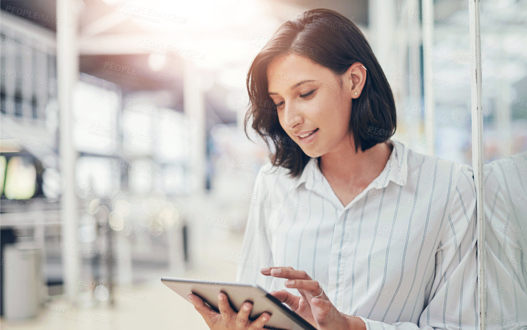 Buy stock photo Shot of a young businesswoman using a digital tablet in a modern office