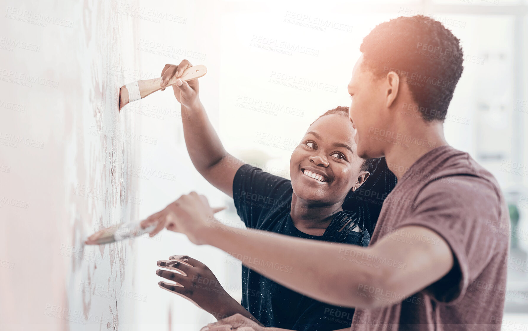 Buy stock photo Shot of a young couple painting a wall pink