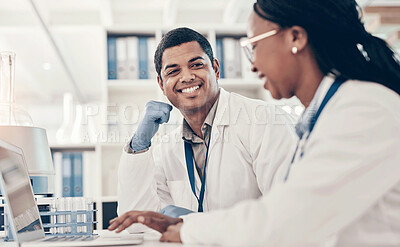 Buy stock photo Shot of two scientists working together on a laptop in a lab