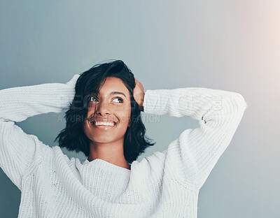 Buy stock photo Cropped shot of a beautiful young woman posing against a teal background