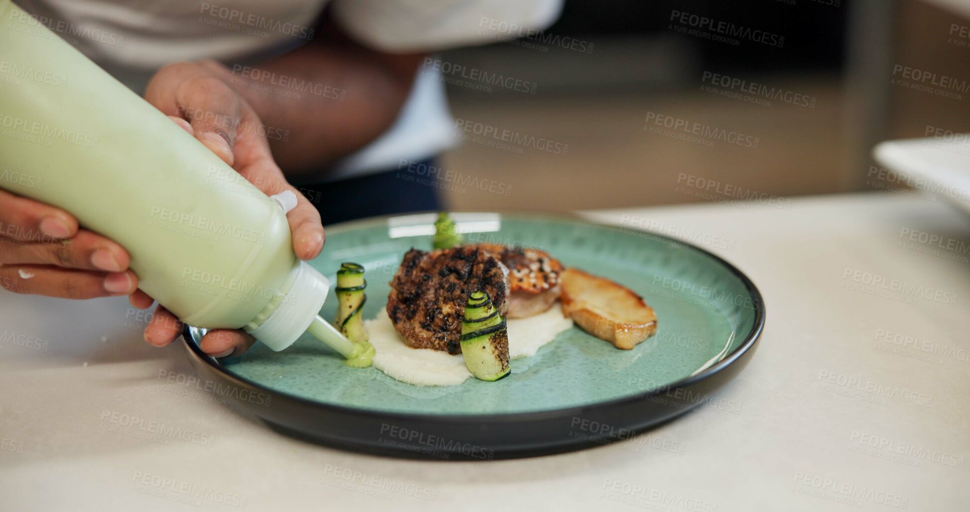 Buy stock photo Hands, food or presentation of dish for fine dining, cooking school or luxury restaurant. Person, healthy meal or sauce on plate for display, catering and hospitality for event on kitchen counter