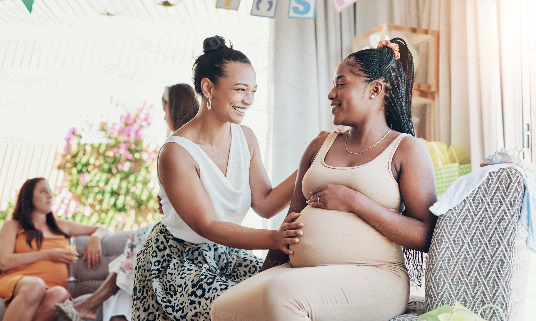 Buy stock photo Shot of a woman touching her friends belly during her baby shower