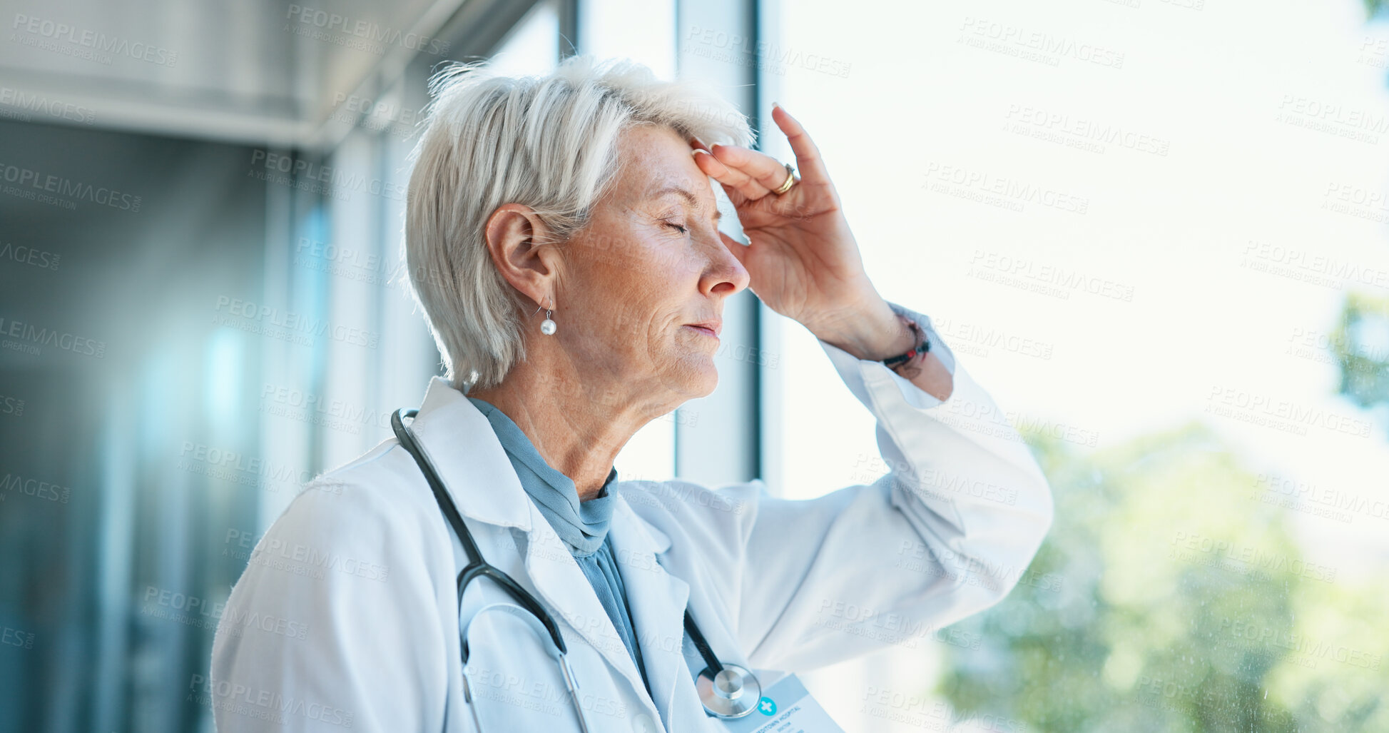 Buy stock photo Senior woman, doctor and headache in stress, burnout or mistake against glass window in hospital building. Frustrated physician, medical healthcare and person in grief, loss or fatigue at clinic