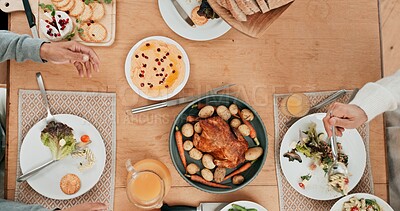 Buy stock photo Dinner, food and roast with people at dining room table of home from above for celebration or hunger. Cooking, meal or supper with family eating in apartment together for event or social gathering