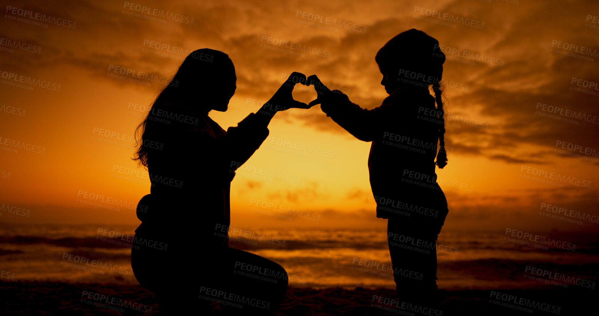Buy stock photo Mom, girl and heart hands at sunset, beach and silhouette with kindness, bonding and care on vacation. Love, mother and daughter with sign, emoji or icon with hands for connection by ocean in Spain