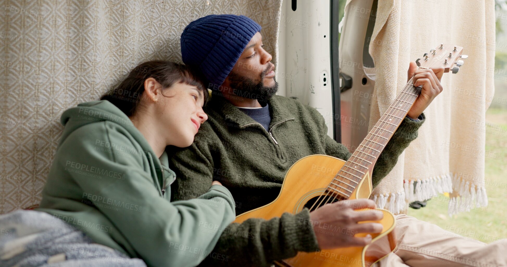 Buy stock photo Interracial, couple and smile with guitar on campsite for honeymoon, holiday and adventure. People, love and happy with music instrument for bonding, support and care with trust on vacation or trip