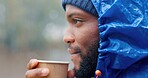 Tea, morning and black man drinking outdoor in winter storm as person for hiking, travel and relax. Hot coffee, peace and freedom in nature for adventure, camping and rain with latte as tourist