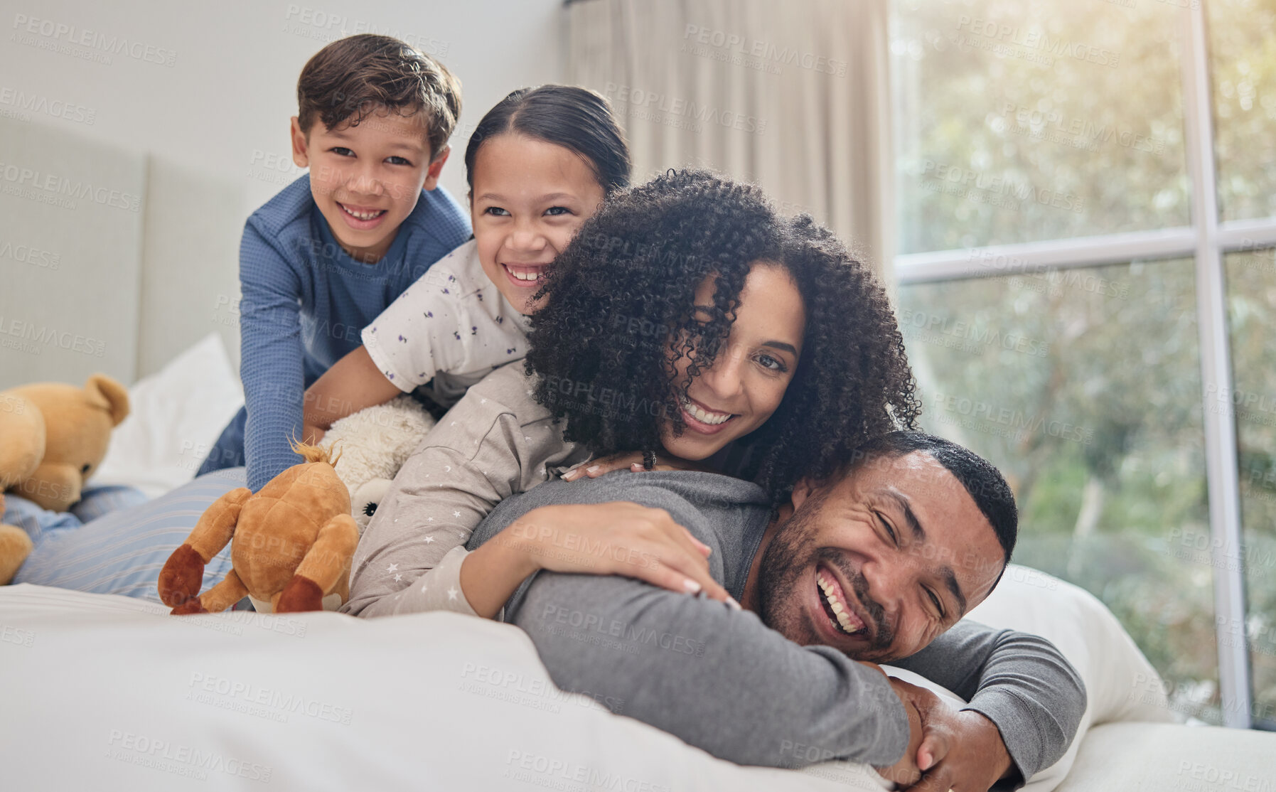 Buy stock photo Love, family and happy with support on bed for bonding, fun game or relax with wake up in morning. Parents, smile or children on back in bedroom with care, trust or relationship with playing in house