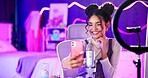 Selfie, influencer and woman with live streaming update in neon bedroom with social media audience, fans or followers. Excited content creator, gamer or streamer by mic, smartphone and gaming at home