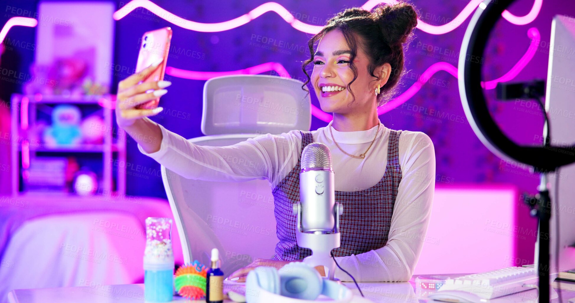 Buy stock photo Selfie, influencer and girl with live streaming update in neon bedroom with social media audience, fans or followers. Excited content creator, gamer or streamer by mic, smartphone and gaming at home