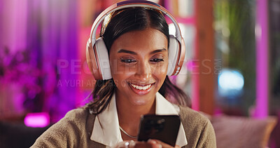 Buy stock photo Phone, headphones and woman streaming music, online game or live chat in home with neon light. Smile, smartphone and girl in lounge with mobile app for social media post, podcast or scroll on video