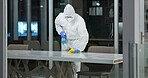 Cleaning table, person and cleaner in office for fumigation, spray disinfect and safety suit from disease risk in building. Maintenance, chemical liquid and pest control of health, hygiene and virus