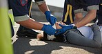 Paramedic, emergency and hands on head injury on road in car crash accident with healthcare help, EMS, wrapping bandage or first responder with victim or rescue in street for transport to hospital