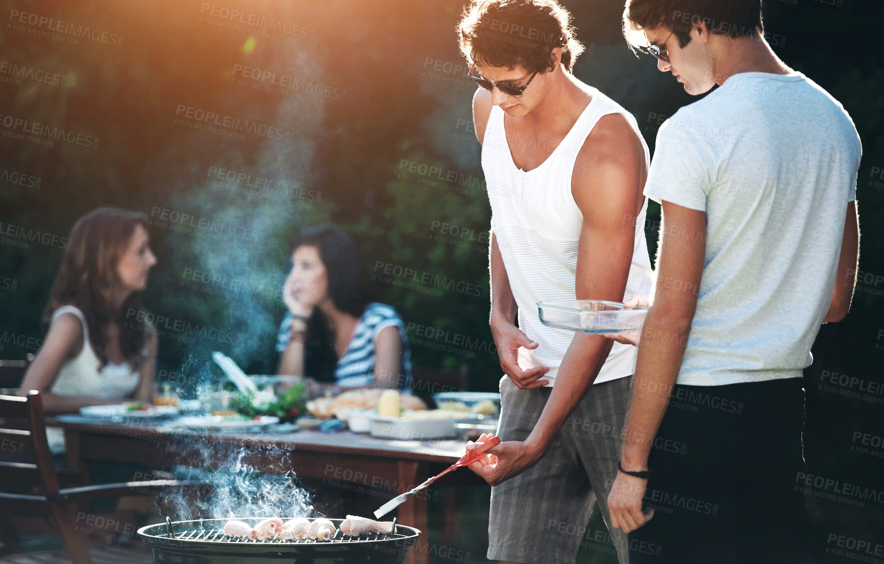 Buy stock photo Young guys barbequing meat on the grill outdoors - Lifestyle