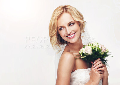 Buy stock photo Young bride holding her bouquet with a sweet smile