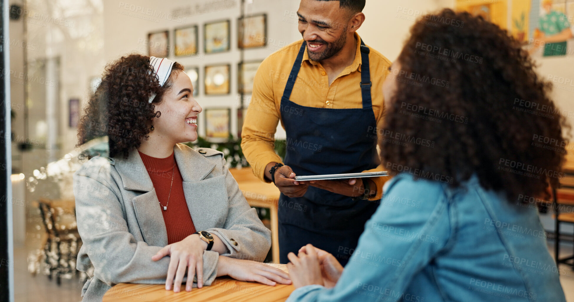 Buy stock photo Cafe, women and waiter order with tablet, conversation and customer service at restaurant. Barista, staff and happy girl friends with smile and chat at coffee shop with employee helping with tech