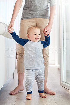 Buy stock photo Parent, boy and baby in home, walking and learning with support, growth and development of child. House, happy and cute toddler with smile, wood and floor in apartment, steps and standing with care