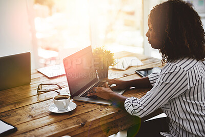 Buy stock photo Cropped shot of a woman using her laptop on a wooden table