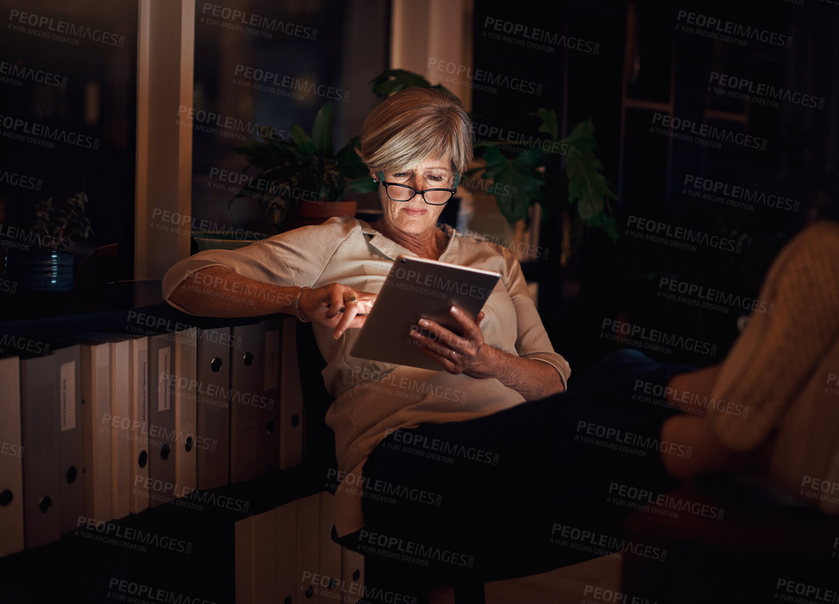 Buy stock photo Mature woman, reading and relax with tablet on sofa for notification, web blog or comfortable in living room. Online, night and person with glasses for information, email or news article in home