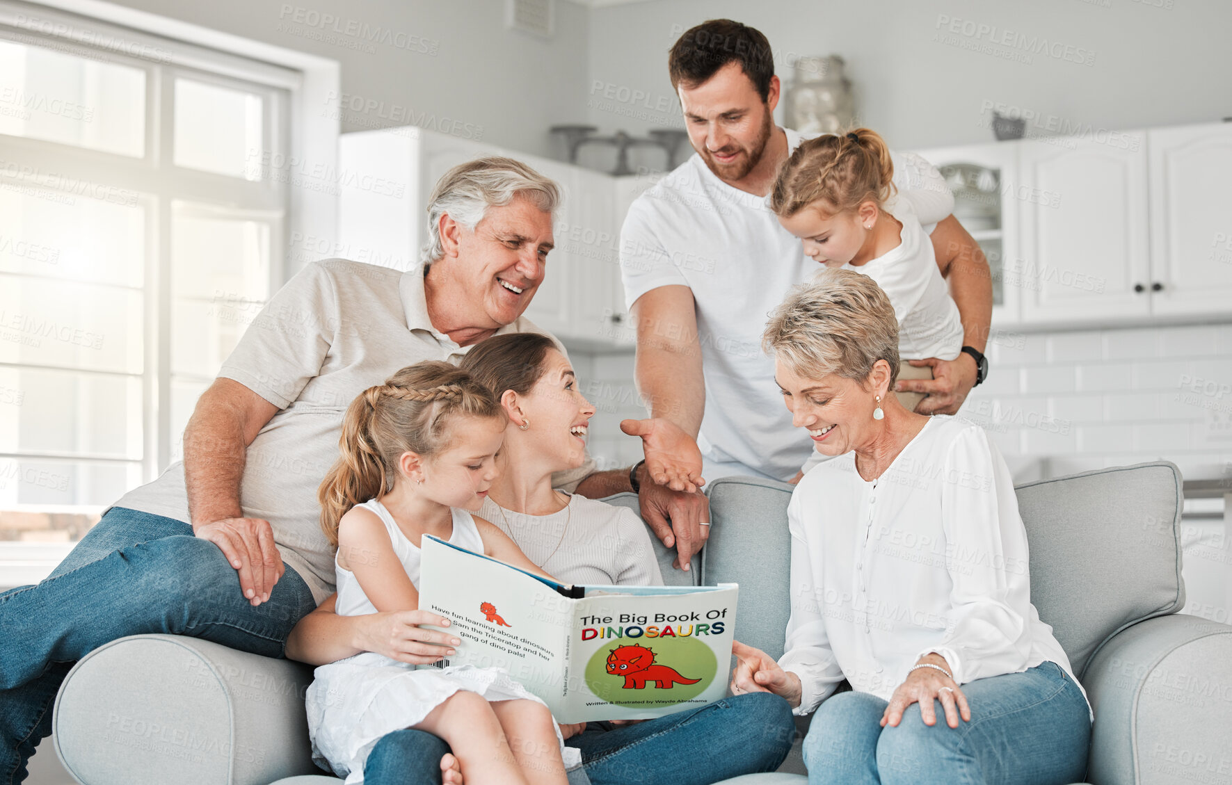 Buy stock photo Happy, big family and reading with book on sofa for kids story of dinosaurs together at home. Parents, grandparents and young children or siblings with novel on couch for quality time or bonding