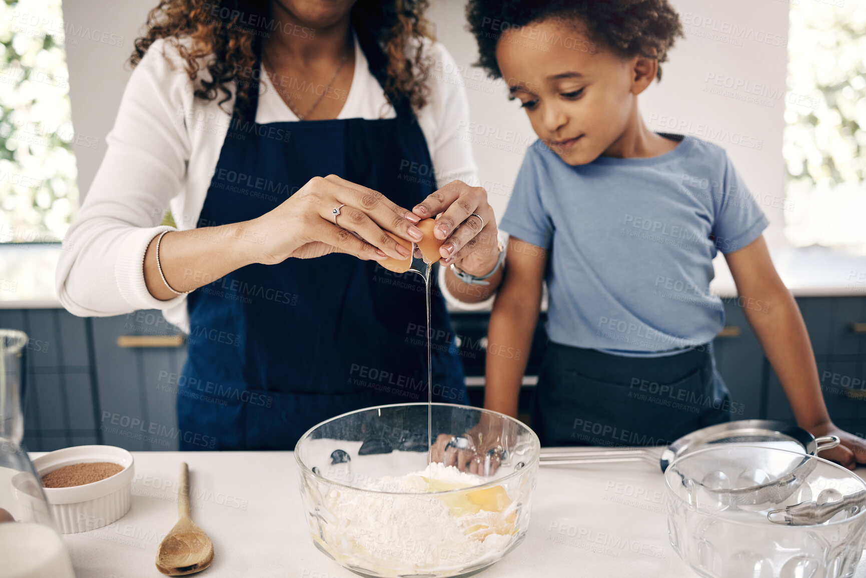 Buy stock photo Closeup of female hands cracking a egg into a bowl while baking at home with her son. Woman adding ingredients to a glass bowl on the counter at home while baking with her child 