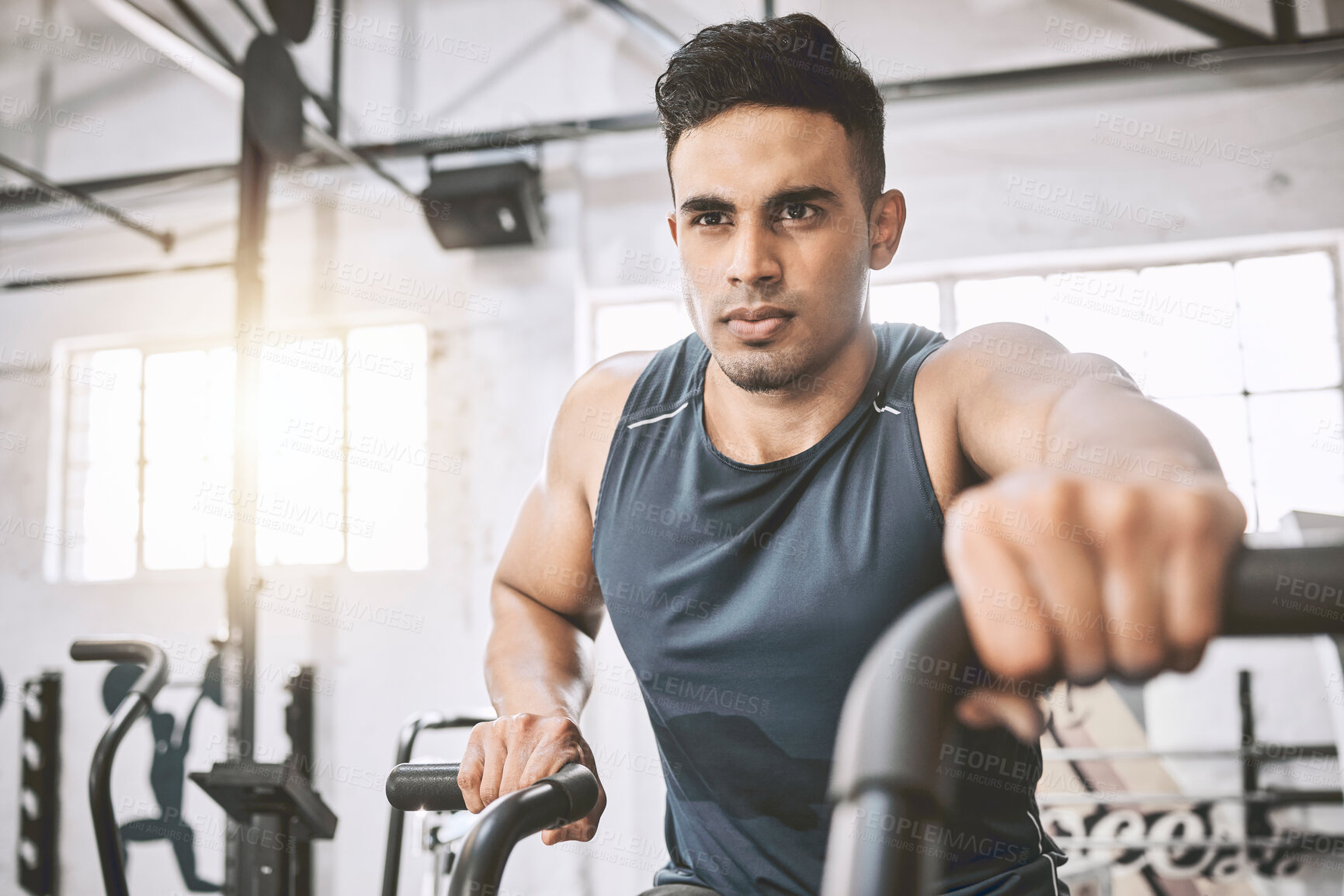 Buy stock photo Fitness, man and bike in gym for exercise, ambition or determination for muscle development. Male athlete, training or energy in sports center for wellness, cycling or endurance for cardio on machine