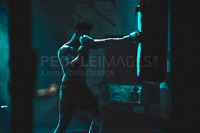 Buy stock photo Man, punching bag and shirtless exercise at gym, training practice and attack challenge for combat. Male person, neon and dojo club aesthetic for boxing competition, athlete and martial arts workout