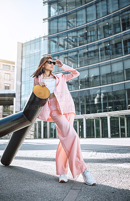 Buy stock photo Sunglasses, trendy woman and fashion in city with thinking, attitude and designer clothing. Stylish, pink suit and accessories by building for outfit, urban downtown and gen z promotion on street