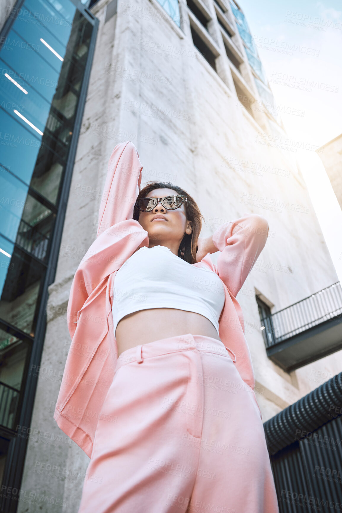 Buy stock photo Sunglasses, woman and fashion in city for attitude, confidence and designer clothing. Stylish low angle, pink suit and accessories by building for outfit, urban downtown and gen z promotion on street