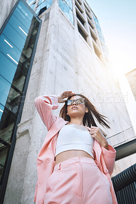 Buy stock photo Sunglasses, woman and fashion in city for confidence, attitude and designer clothing. Stylish low angle, pink suit and accessories by building for outfit, urban downtown and gen z promotion on street