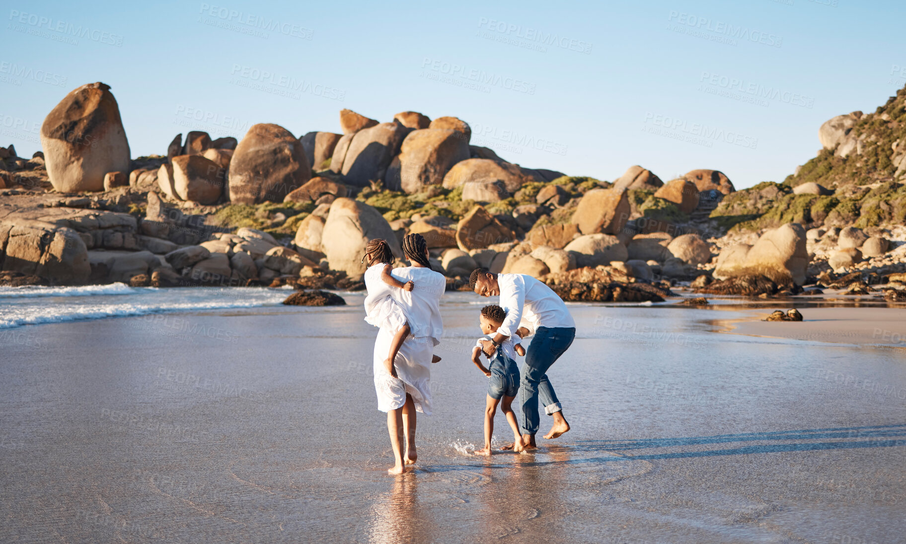 Buy stock photo Family, summer and walking at beach for bonding, travel and vacation with sand, smile and support. Parents, children and people carrying for relationship, relax and holiday in Santorini with love