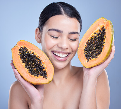 Buy stock photo Woman, calm and papaya in studio for skincare or natural cosmetics, facial treatment and enzyme exfoliation. Girl, eyes closed and fruit on blue background for antioxidants, skin tone and hydration.