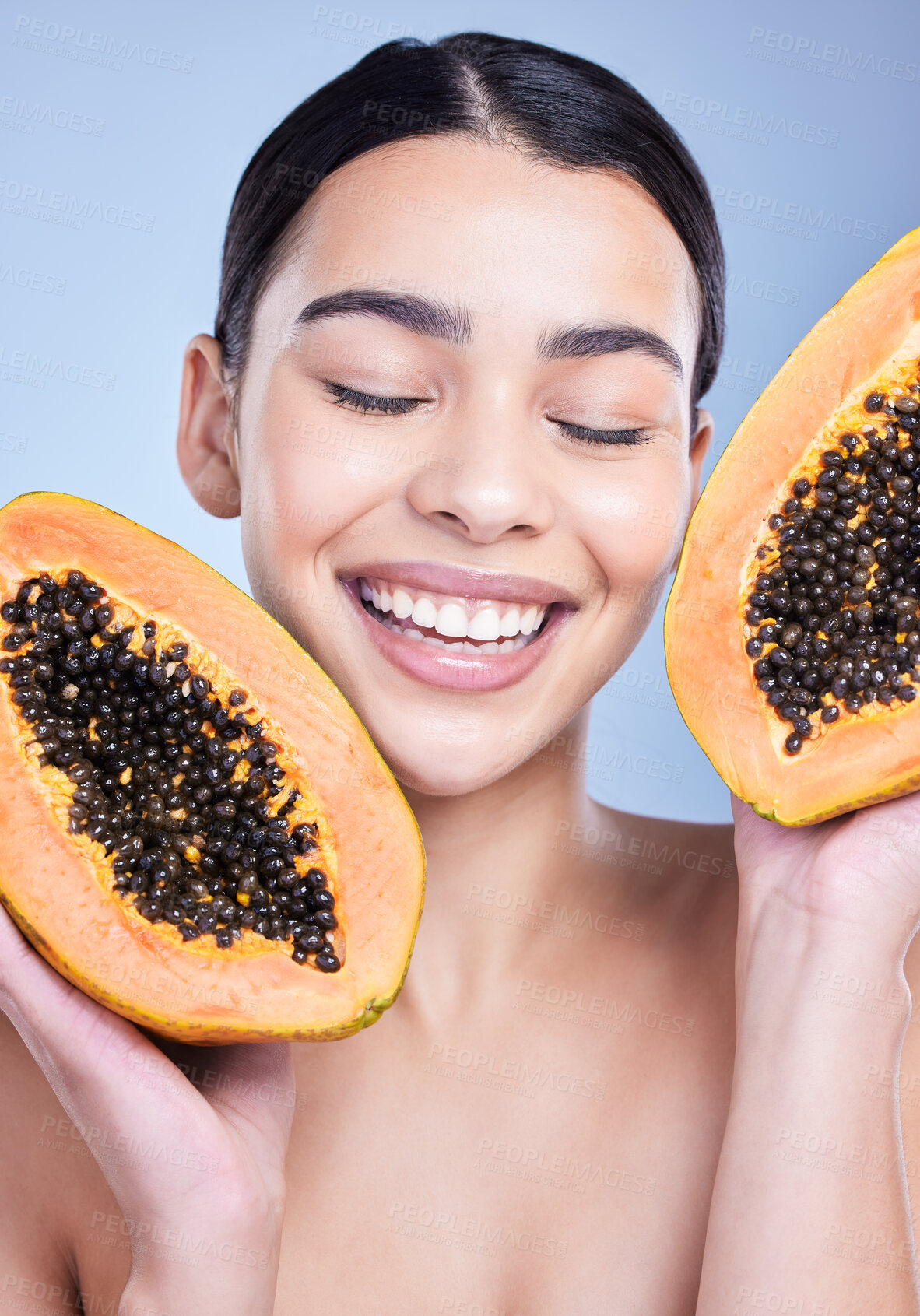 Buy stock photo Girl, calm and papaya in studio for skincare or natural cosmetics, facial treatment and enzyme exfoliation. Woman, eyes closed and fruit on blue background for antioxidants, skin tone and hydration.