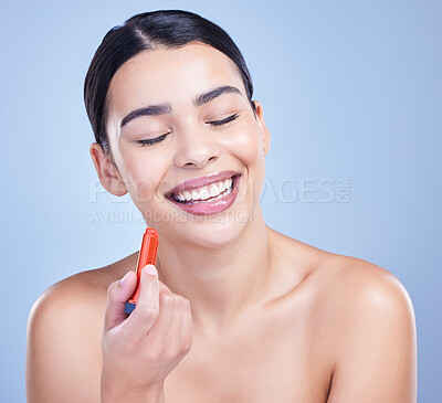 Buy stock photo Woman, laughing and red lipstick in studio with makeup for beauty cosmetics on blue background. Smile, funny person or model applying color, gloss or glow for cosmetology, dermatology or treatment