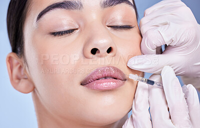 Buy stock photo Cosmetic surgery, girl and hands with filler in lips for facial transformation, beauty and change in studio. Syringe, surgeon or woman patient with injection for makeover treatment on blue background