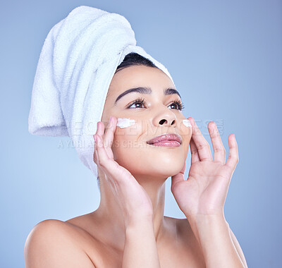 Buy stock photo Skincare, woman and cosmetics with shine, cream or dermatology on blue studio background. Person, beauty or model with towel, grooming routine or creme with treatment, wellness or soft skin with glow